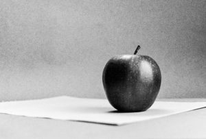 Miscellany shows a 35mm B&W film photo image of a still life with an apple on a table with a plane blank background