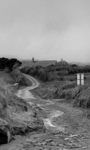 Quiet Rural Paths shows a 35mm B&W film image of a lane on the Dingle Peninsula with a church in the background in rural County Kerry