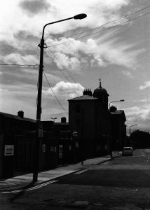 Quiet Spaces shows a 35mm black and white photo of a streetscape of old buildings in Grangegorman Dublin City