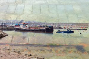 Boat in Harbour show a double exposure digital colour 35mm image of a boat plus old underwater rails and paving stonework in Dun Laoghaire harbour, Co Dublin