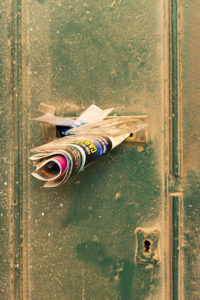 Vanishing Malta IV shows a 35mm digital colour image of a letter box on a dirty and dilapidated door. The box is full of junk mail.