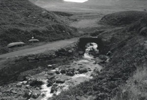 Dingle Peninsula Ireland shows 35mm black and white film photograph of Brandon Creek and upturned currachs on the peninsula