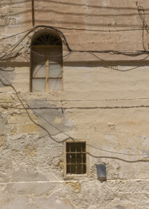 Vanishing Malta shows a 24mm digital colour image of an old and now empty and dilapidated building awaiting its fate.