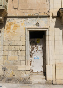 Vanishing Malta shows a 24mm digital colour image of an old and now empty and dilapidated building awaiting its fate.