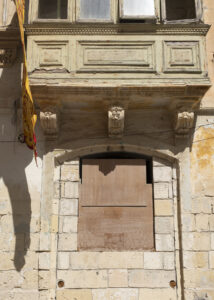 Vanishing Malta shows a 24mm digital colour image of an old and now empty and dilapidated sandstone building awaiting its fate.