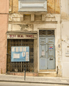 Vanishing Malta 2025 shows a 35mm digital colour image of a disused and delapitated shop that once housed a travel agent
