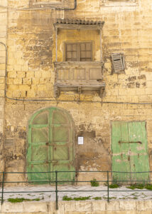 Vanishing Malta VI shows a series of dilapidated green doors in 35mm digital colour, all still awaiting their fate in 2025.