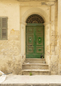 Vanishing Malta VI shows a series of dilapidated green doors in 35mm digital colour, all still awaiting their fate in 2025.